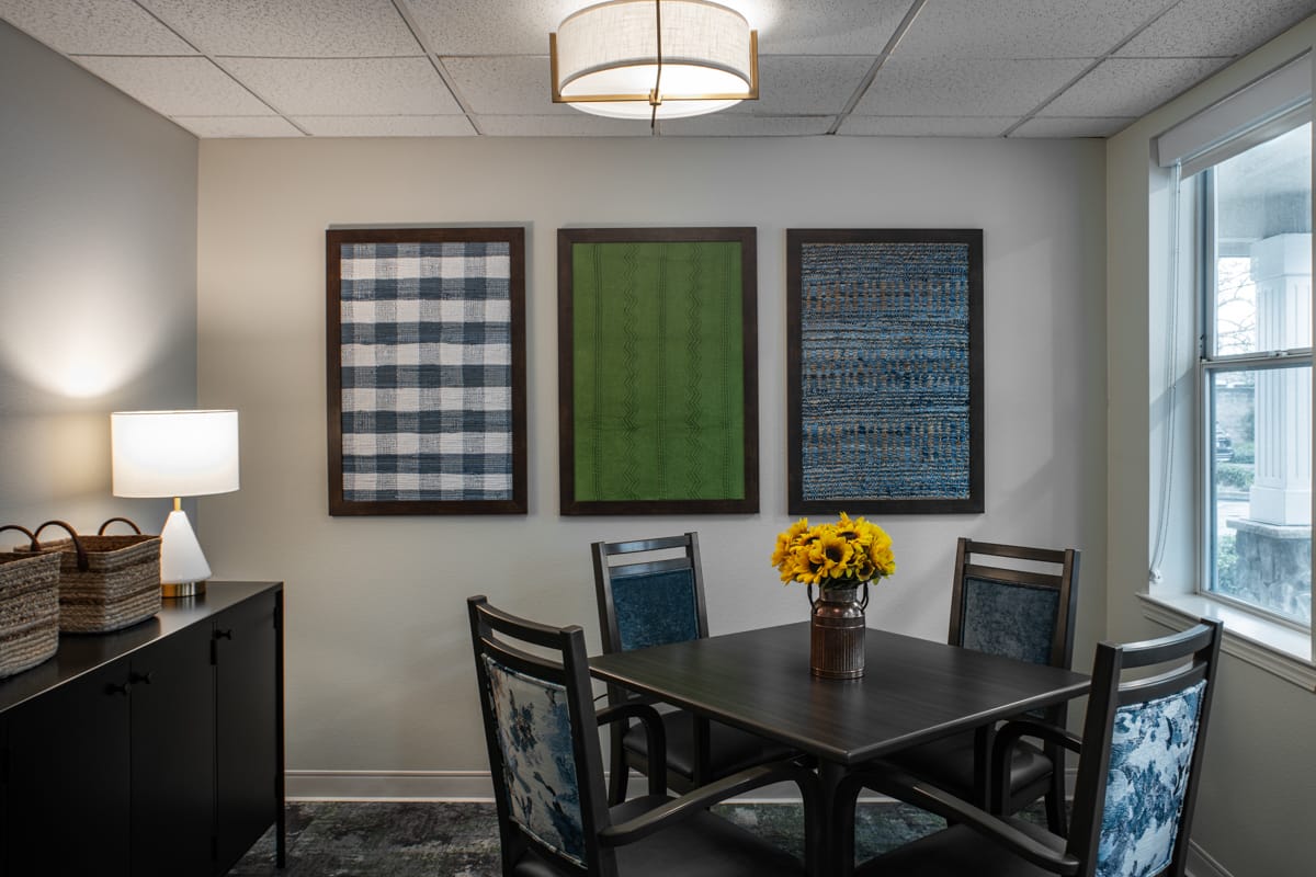 Small dining nook with framed textile art and a table for four